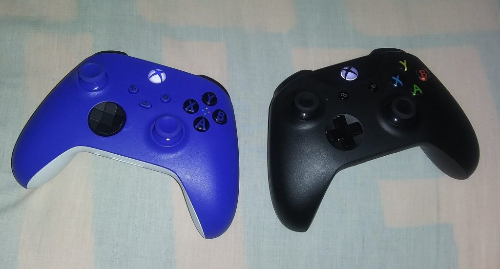 Blue Xbox Series X controller next to a black Xbox One controller